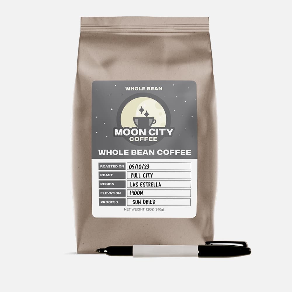 Writable matte paper coffee label on a kraft coffee bag with a marker.