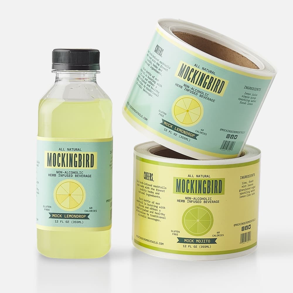 Custom glossy paper labels on rolls applied to Mockingbird beverage bottles with a bright, high-shine finish.