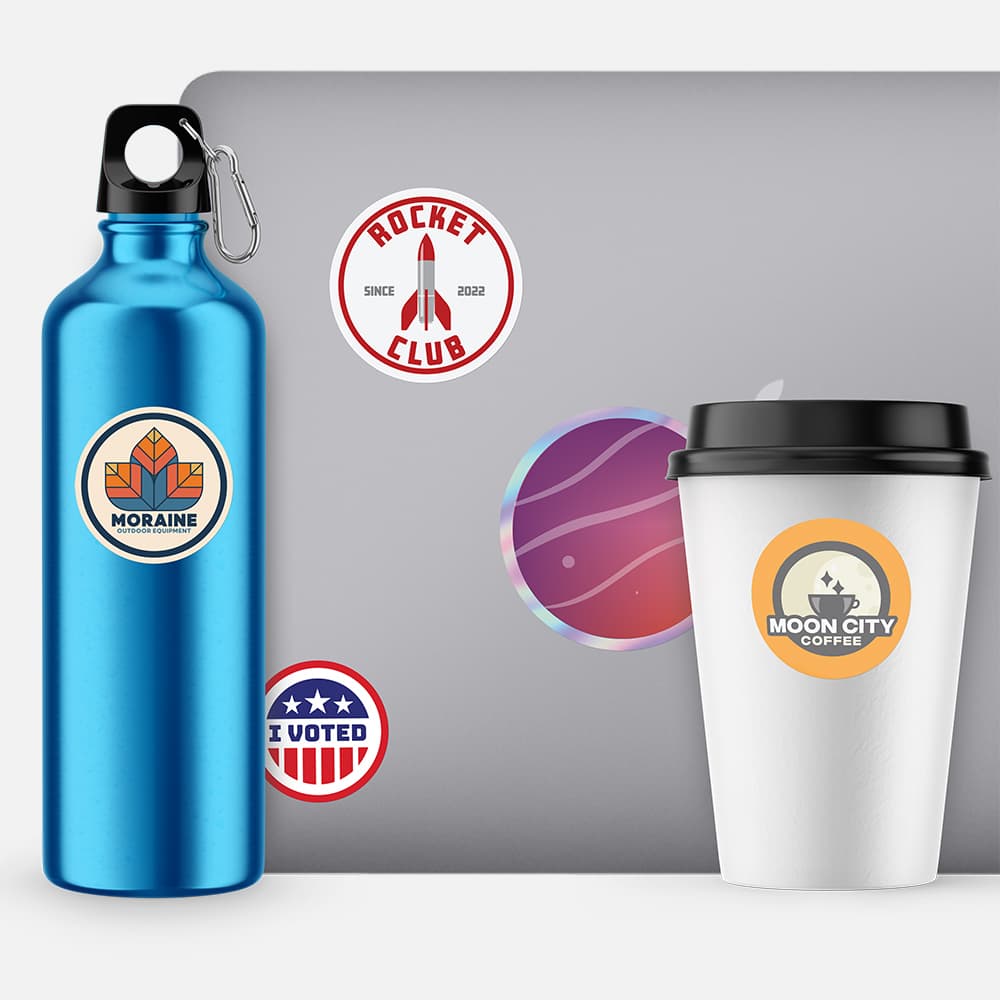 A water bottle, laptop and coffee cup with Circle Stickers printed by StickerGiant on them